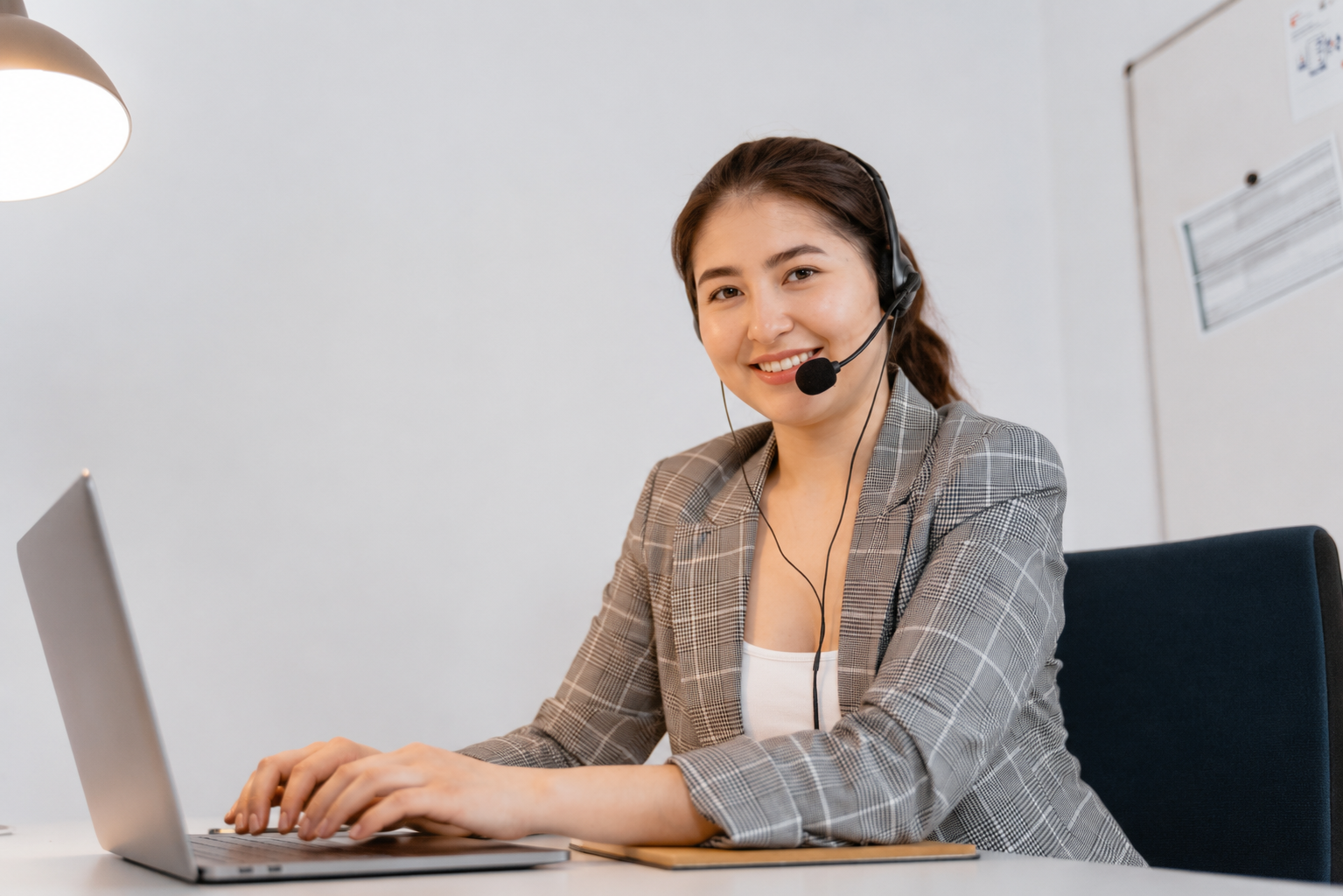 Atendente sorridente com headset em escritório de suporte